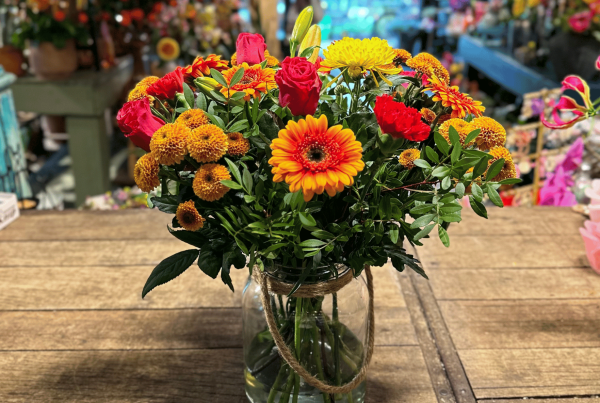 Happy Orange arrangement met een stralende mix van oranje bloemen en natuurlijke accenten.